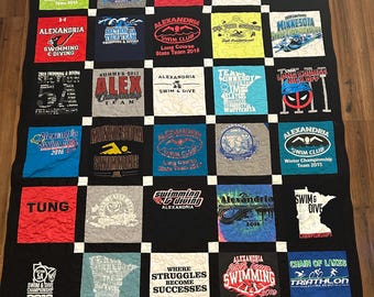 May include: A handmade quilt featuring various swimming and diving team t-shirts. The quilt is primarily black with white squares separating the t-shirt designs. The t-shirts display team names, logos, and event details.