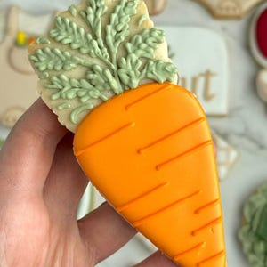 Farmers market-themed baby shower sugar cookies featuring hand-decorated designs like “little sprout,” baby onesies with vegetables, carrots, corn, strawberries, tomatoes, baby bottles, mason jars, leafy greens, and baby mobiles. Adorned with soft green, beige, orange, and red royal icing, these custom cookies are perfect for a “locally grown” or garden baby shower theme, gender-neutral celebrations, and personalized baby gifts.