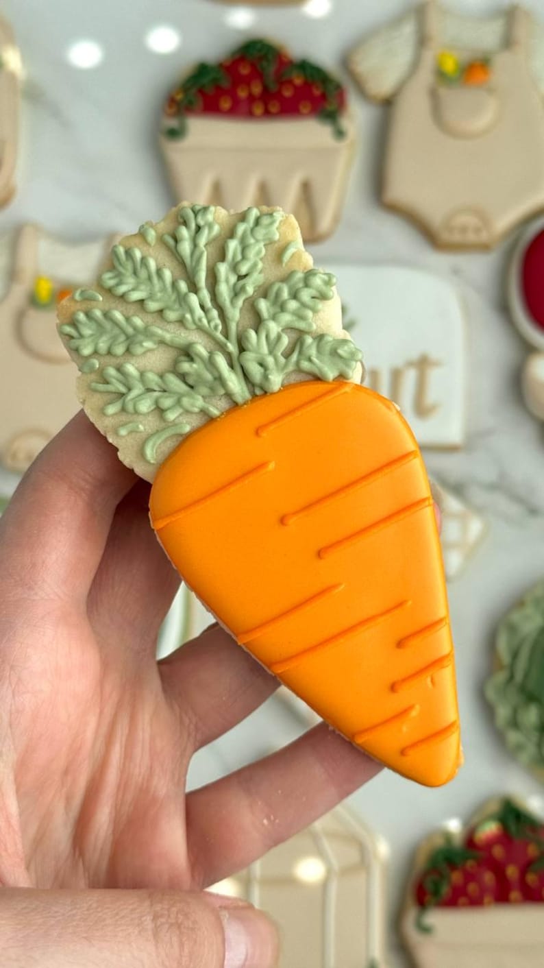 Farmers market-themed baby shower sugar cookies featuring hand-decorated designs like “little sprout,” baby onesies with vegetables, carrots, corn, strawberries, tomatoes, baby bottles, mason jars, leafy greens, and baby mobiles. Adorned with soft green, beige, orange, and red royal icing, these custom cookies are perfect for a “locally grown” or garden baby shower theme, gender-neutral celebrations, and personalized baby gifts.