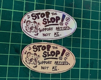 May include: Two oval stickers featuring the text STOP THE SLOP! SUPPORT ARTISTS, NOT AI. The design includes a stylized character head, a small bird, and an AI symbol. One sticker has a holographic finish, while the other has a solid cream background.