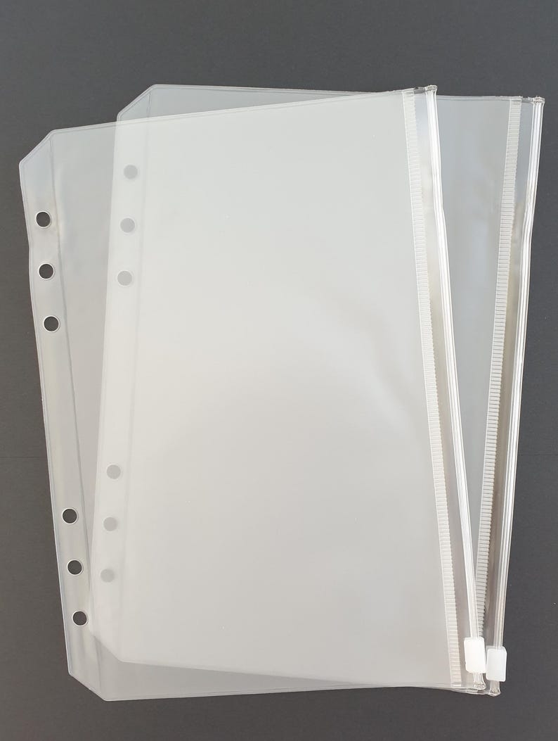 May include: Two clear plastic zippered pouches with holes for a binder. The pouches are stacked on top of each other.