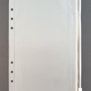 May include: Clear plastic zippered pouch with six holes along the left side for use in a binder or planner.