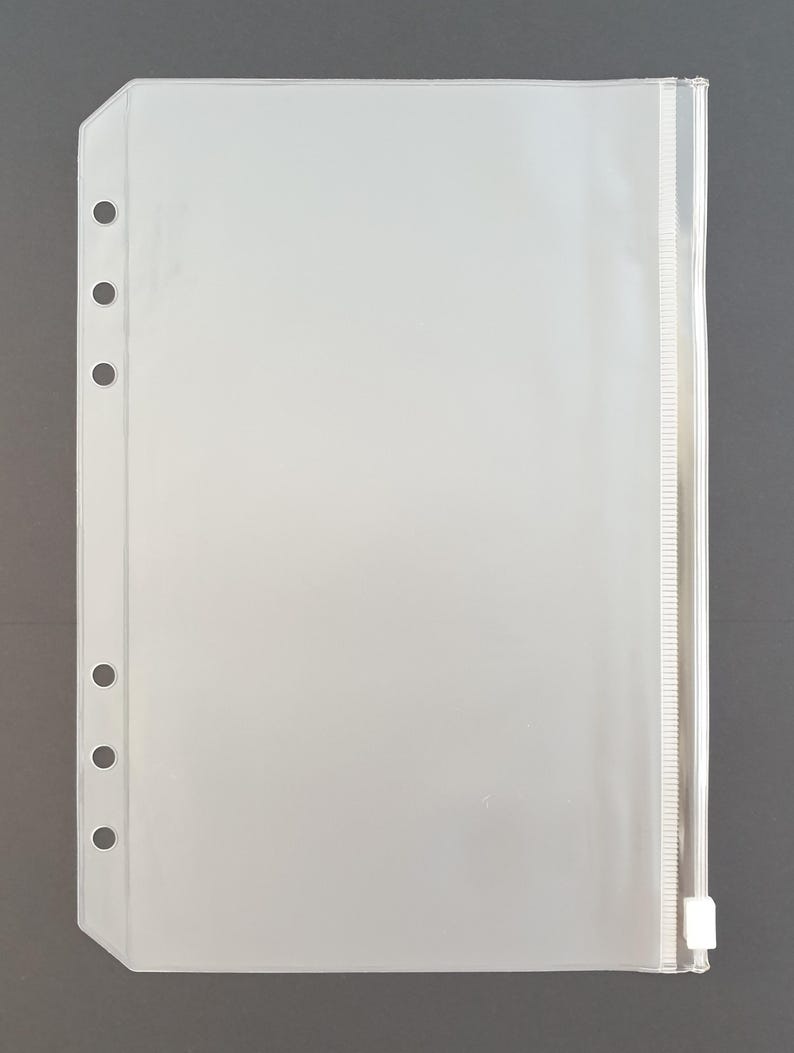 May include: Clear plastic zippered pouch with six holes along the left side for use in a binder or planner.
