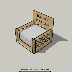 May include: A wooden laser-cut notepad holder with a geometric design. The holder has a rectangular base and a back panel with the text "BAHRY DESIGN." The holder is designed to hold a stack of white notepaper. The text "LASER CUT DIGITAL FILES" is also visible.