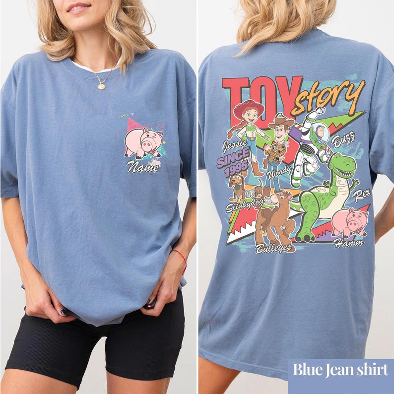 May include: Blue jean-colored t-shirt featuring a front pocket with a pig graphic and the word "Name". The back of the shirt displays a "Toy Story" graphic with characters like Woody, Buzz, and Jessie. The text "Since 1995" is also visible.