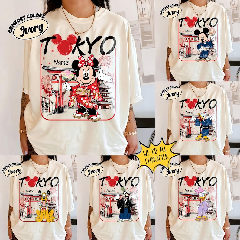 May include: Ivory-colored t-shirts with a graphic featuring a Disney character in traditional Japanese attire, the word "TOKYO", and a customizable name field. The shirts have a Comfort Colors label.