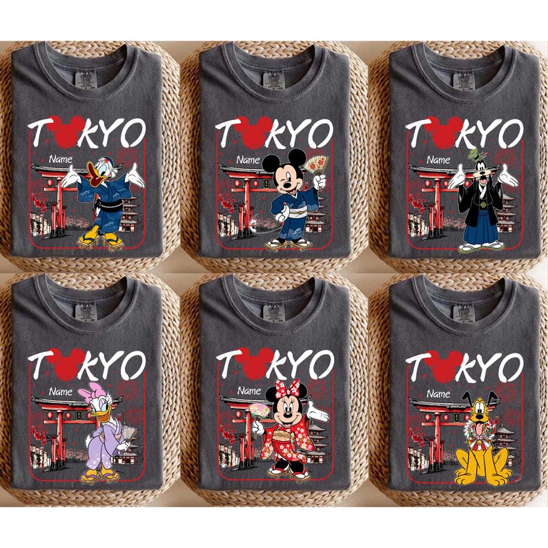 May include: Six gray t-shirts with the word "TOKYO" in white and a red heart. Each shirt features a different Disney character in traditional Japanese attire, with the text "Name" below the word "TOKYO".