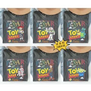 Peut inclure: Six t-shirts gris avec diff&eacute;rents personnages de Toy Story. Chaque chemise pr&eacute;sente un graphisme color&eacute; avec le logo Pixar, les mots "TOY STORY" et une image de personnage. Les chemises sont pr&eacute;sent&eacute;es avec un chapeau et du denim.