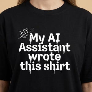 Könnte beinhalten: Schwarzes T-Shirt mit dem weißen Text "My AI Assistant wrote this shirt." Der Text hat einen tropfenden Farbeffekt. Das T-Shirt ist ein Rundhals-Stil.