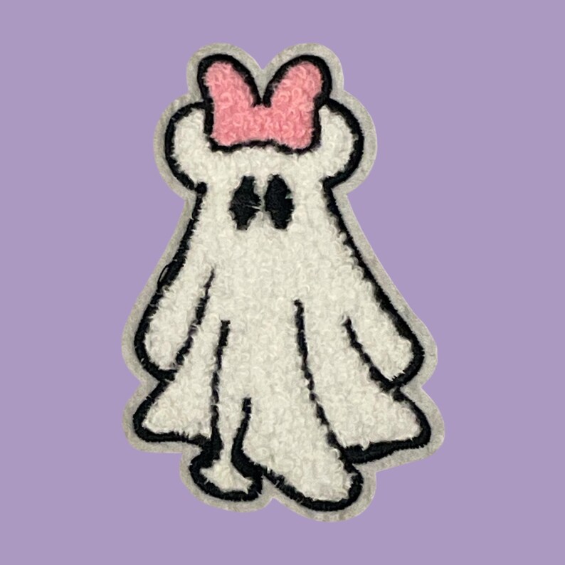 May include: A white ghost with a black outline and a pink bow on its head. The ghost has two black eyes and a small mouth.