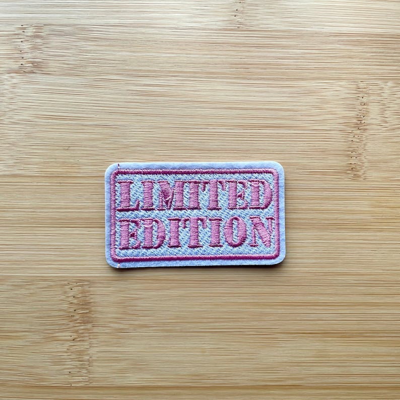 May include: A white patch with a pink embroidered border and the text "LIMITED EDITION" in pink.