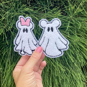 May include: Two white felt ghost patches with black eyes. One ghost has a pink bow on its head.
