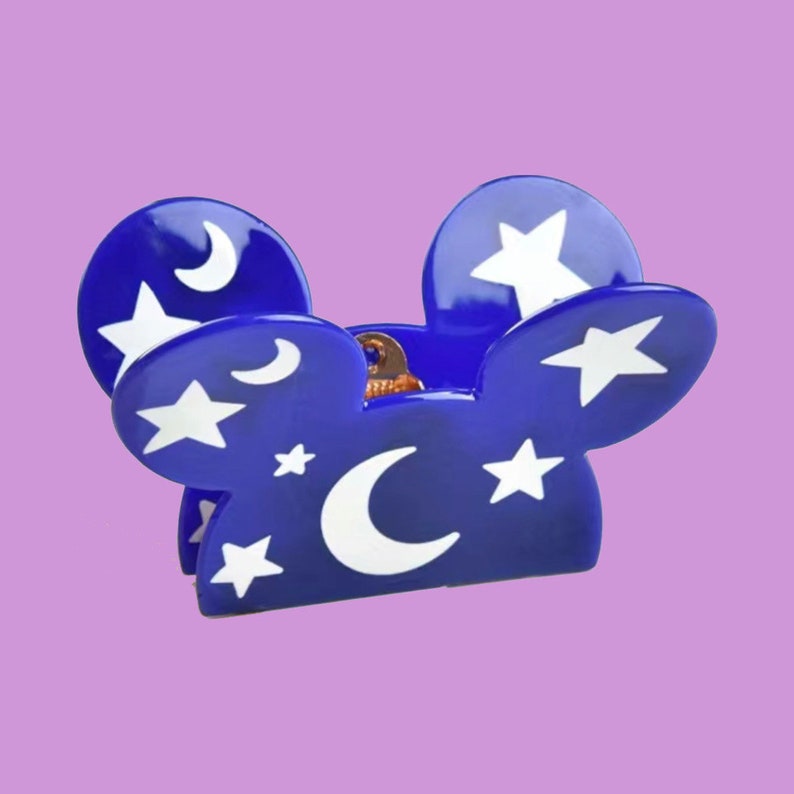May include: Blue plastic hair clip shaped like Mickey Mouse ears with a white crescent moon and star pattern.