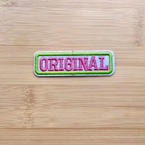May include: A white patch with a green border and the word "ORIGINAL" embroidered in pink.