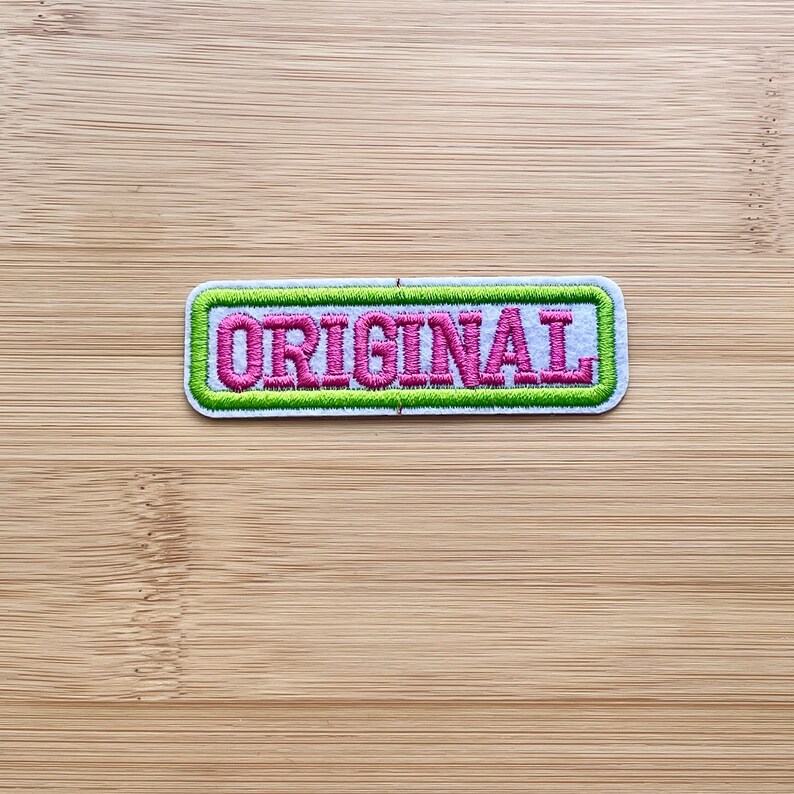 May include: A white patch with a green border and the word "ORIGINAL" embroidered in pink.