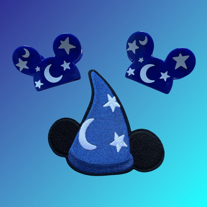 May include: Three blue felt patches with white stars and crescent moons. One patch is shaped like a wizard's hat with a black felt brim. The other two patches are shaped like Mickey Mouse ears.