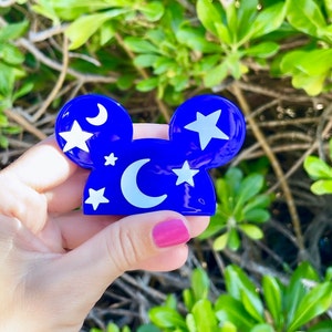 May include: Blue Mickey Mouse ears with white stars and a crescent moon design.