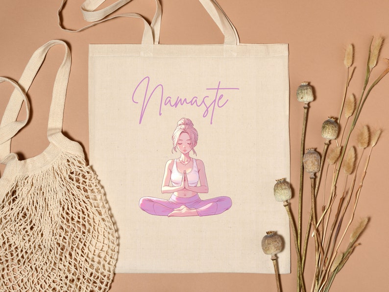 May include: Beige tote bag with the word "Namaste" in lavender script above an illustration of a meditating person. The person is wearing a white top and pink pants. A beige string bag is on the left.