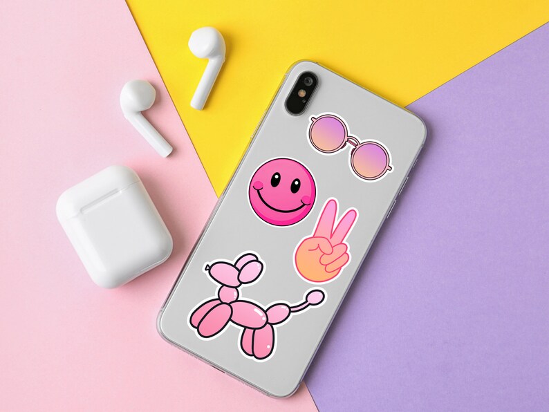 Op de afbeelding: Een witte telefoonhoes met roze en oranje stickers. De stickers bevatten een smiley, een vredesteken, een zonnebril en een roze ballondier.
