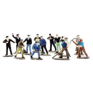 May include: A group of miniature figurines of workers in various poses. The figures are dressed in work clothes, including jackets, hats, and overalls. Some figures are holding tools like pickaxes and shovels. The figurines are painted in various colours.