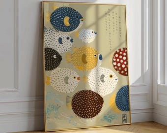 Peut inclure: Une impression d'art encadrée représentant plusieurs poissons-globes stylisés de différentes couleurs, dont le bleu, le jaune, le blanc et le marron, sur un fond beige clair. L'œuvre a une esthétique japonaise, avec des motifs de vagues et du texte.