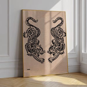 Puede incluir: Un póster beige con una ilustración en blanco y negro de dos tigres enfrentados. El póster tiene la palabra "TIGER" impresa en la parte inferior.