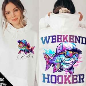 Pode incluir: Casaco de moletom branco com capuz com um peixe colorido usando óculos de sol e um chapéu. O texto "Weekend Hooker" está impresso no moletom.