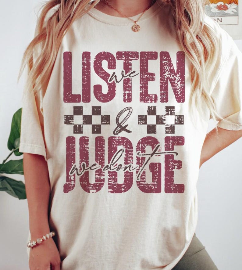 May include: A white t-shirt with a distressed red graphic that says "We Listen & We Don't Judge" with black and white checkered squares.