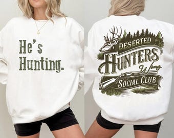 May include: Two white sweatshirts with different designs. One sweatshirt has the text "He's Hunting." printed in green. The other sweatshirt has a green graphic of a deer, a rifle, and the text "Deserted Hunters Wing Social Club".