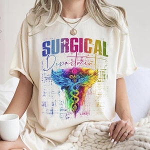 May include: A white t-shirt with a rainbow colored medical caduceus graphic and the text "SURGICAL Department".