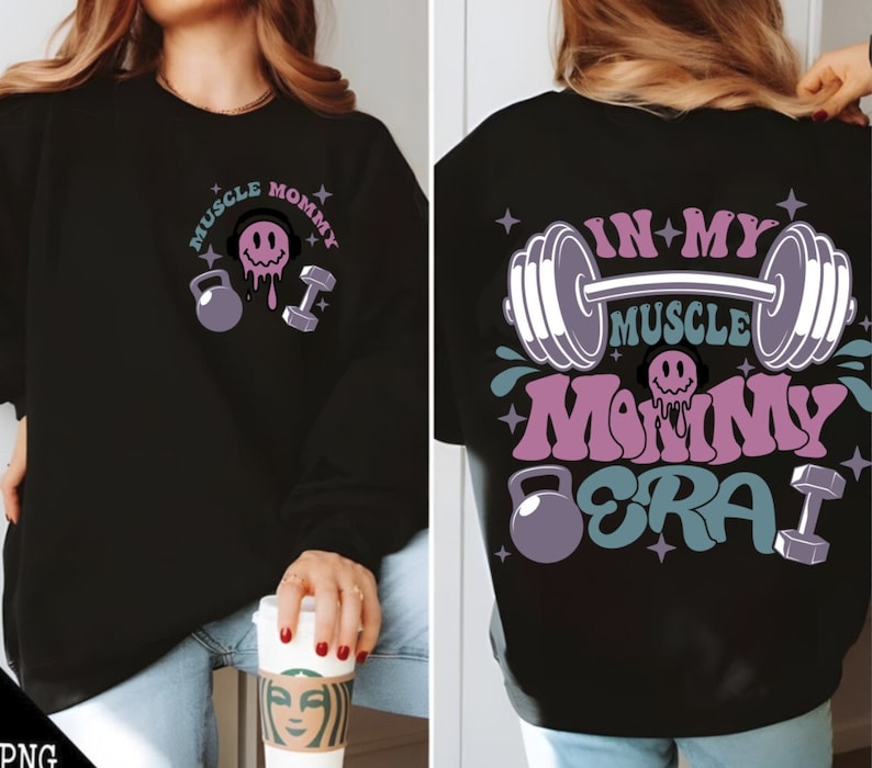 May include: Black sweatshirt with a pink and blue graphic design that says "Muscle Mommy Era" with a barbell, dumbbells, and a smiley face.