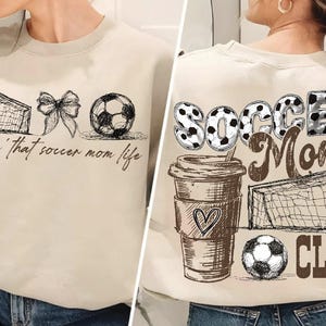 Może przedstawiać: Beżowa bluza z motywem piłkarskim. Z przodu znajduje się siatka do piłki nożnej, kokarda, piłka nożna i napis "Livin' that soccer mom life". Z tyłu kubek do kawy, piłka nożna, siatka i napisy "Soccer Moms Club".