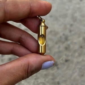 May include: A brass level pendant with a clear glass bubble inside. The bubble is filled with a yellow liquid.