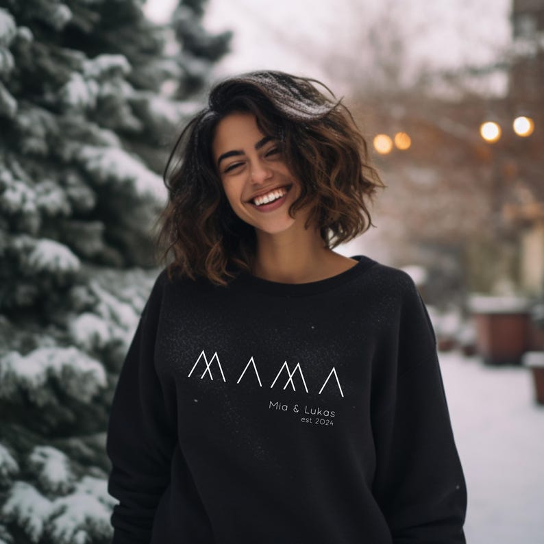 May include: A black sweatshirt with a white graphic design of stylized mountains and the text "MAMA Mia & Lukas est. 2024".