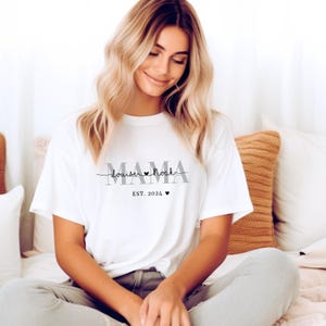 Może przedstawiać: Biała koszulka z napisem "MAMA" w szarych literach, z napisem "louise &hearts; noah" w czarnym pismem poniżej i "EST. 2024" w szarych literach poniżej.