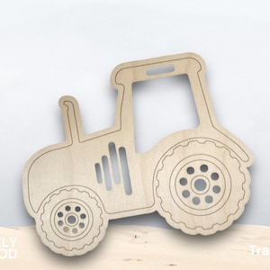 May include: A wooden tractor cutout with a light brown finish. The tractor features detailed wheel designs and a cabin outline. The word "Tractor" is printed in white. The brand name "Oakly Wood" is printed in white.