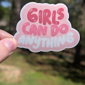 Può includere: Sticker rosa e bianco con il testo "Girls Can Do Anything" in un font a bolle.
