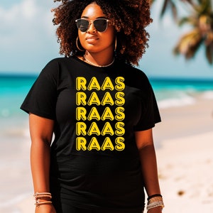 Puede incluir: Una camiseta negra con un gráfico amarillo que dice "RAAS" repetido cinco veces.