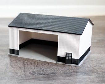 Könnte beinhalten: Ein weißes und schwarzes Miniaturmodell einer Garage mit einem schwarzen Dach und einer einzigen Tür.