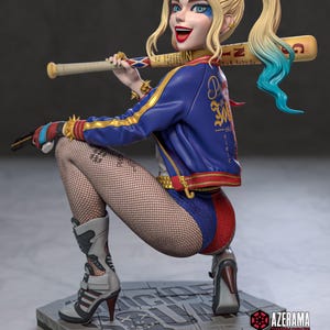 Puede incluir: Figura detallada de un personaje con coletas rubias, atuendo azul y rojo, y medias de rejilla, sosteniendo un bate de béisbol. La figura está posada sobre una plataforma gris, con un diseño dinámico y expresivo. La chaqueta del personaje es azul con detalles dorados.