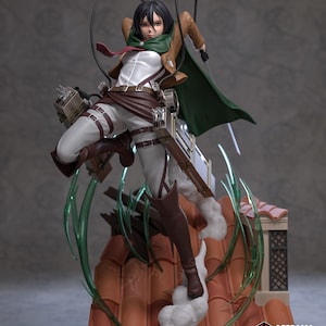 Op de afbeelding: Een gedetailleerd actiefiguur van een vrouwelijk personage uit de anime Attack on Titan. Ze draagt een bruin en groen militair uniform met een rode stropdas. Ze houdt een zwaard in haar rechterhand en heeft een vastberaden uitdrukking op haar gezicht. Het figuur is geposeerd in een dynamische actiestand, met haar benen gestrekt en haar armen omhoog. Het figuur is geplaatst tegen een achtergrond van een grijze muur en een kapot dak.