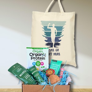 May include: A gift box filled with health and wellness products, including a tote bag with a runner graphic, protein powder, bath products, and a lip balm. The tote bag has the text "NAME OR TEXT HERE".