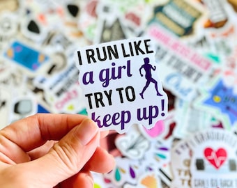 May include: A white sticker with the text "I RUN LIKE a girl TRY TO keep up!" in black and purple. A purple silhouette of a runner is also on the sticker. The sticker is held in a hand, with other stickers in the background.