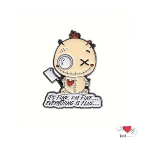 May include: A cartoon-style pin featuring a voodoo doll character with a cleaver. The doll has a stitched body, a heart-shaped patch, and the text "IT'S FINE, I'M FINE.... EVERYTHING IS FINE...." in a speech bubble.