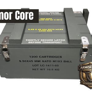 K&ouml;nnte beinhalten: Eine rechteckige olivgr&uuml;ne Holzkiste mit Metallverschl&uuml;ssen. Der Deckel tr&auml;gt die Aufschrift 5.56 X 45 MM NATO M193 1200 RDS und TIGHTLY SECURE LATCH BEFORE TRANSPORT. Die Vorderseite zeigt 1200 CARTRIDGES, 5.56X45 MM NATO M193 BALL, LOT LC-1411-65, NET WT 19.5 KG und ein Armor Core Logo.
