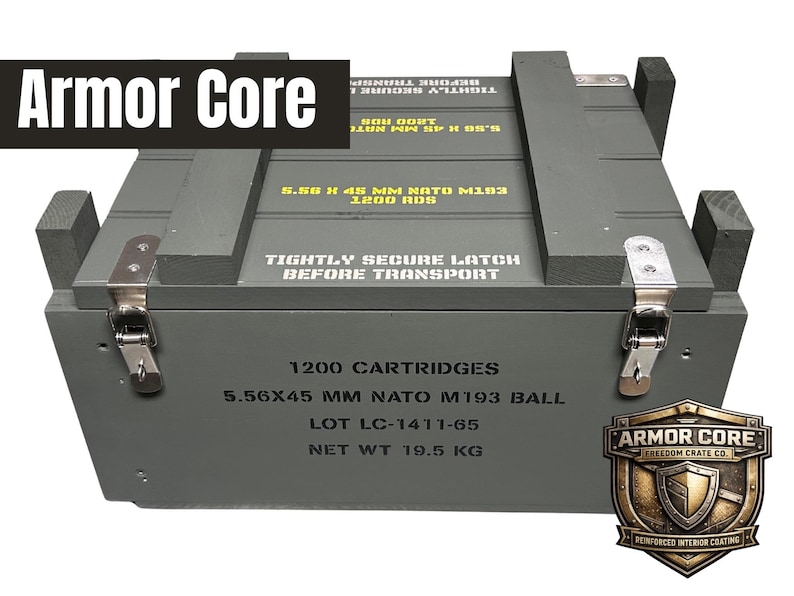 K&ouml;nnte beinhalten: Eine rechteckige olivgr&uuml;ne Holzkiste mit Metallverschl&uuml;ssen. Der Deckel tr&auml;gt die Aufschrift 5.56 X 45 MM NATO M193 1200 RDS und TIGHTLY SECURE LATCH BEFORE TRANSPORT. Die Vorderseite zeigt 1200 CARTRIDGES, 5.56X45 MM NATO M193 BALL, LOT LC-1411-65, NET WT 19.5 KG und ein Armor Core Logo.