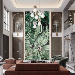 May include: An interior design with a large mosaic of green tropical leaves. The room features a brown sectional sofa, two green armchairs, and a modern chandelier. Bronze sculptures and dark wood paneling contribute to the luxurious aesthetic.