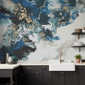 Może przedstawiać: Kuchnia z mozaikową ścianą z abstrakcyjnym wzorem w kolorze niebieskim, białym i złotym. Kuchnia posiada ciemne szafki, biały zlew i złotą baterię. Półki z naczyniami i małą rośliną doniczkową.