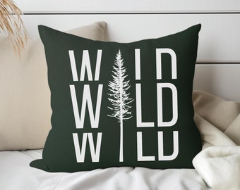 Cojín decorativo con diseño de pino, estampado salvaje en verde y blanco, ideal para decorar el hogar y crear una atmósfera de aventura al aire libre en una cabaña rústica.