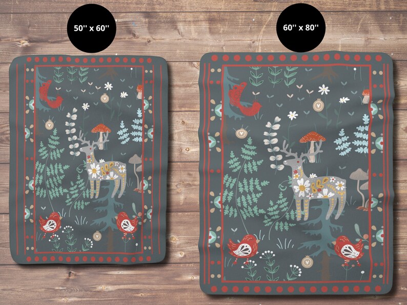 May include: A dark blue fleece blanket with a whimsical forest scene featuring a deer, mushrooms, birds, and flowers. The blanket has a red and white border.